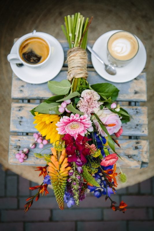 personal branding photo close-up image colourful flowers with coffee outdoor on rustic wooden table colour image natural light brand product photography